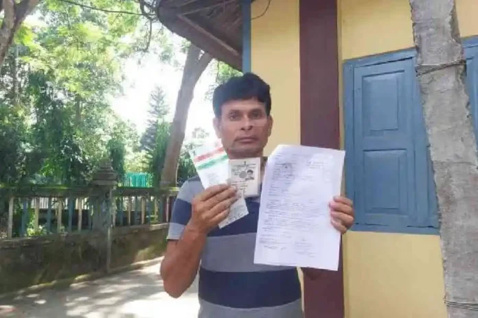 Uttam Brajabashi shows his identity proofs and the notice from the Assam Foreigner’s Tribunal in Dinhata on Sunday. Picture by Main Uddin Chisti/The Telegraph