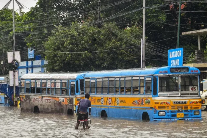Buses move through a waterlogged road after heavy rain, in Kolkata. PTI/The Telegraph
