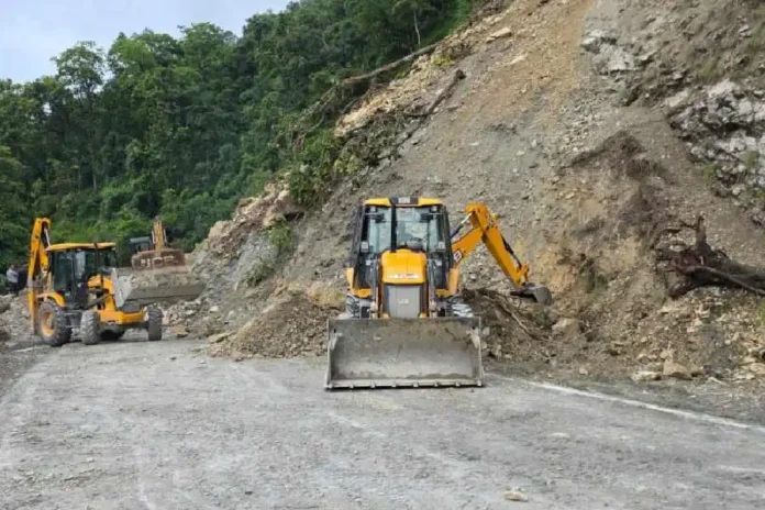 Earthmovers clear the debris from NH10 near Birikdara on Saturday. The Telegraph
