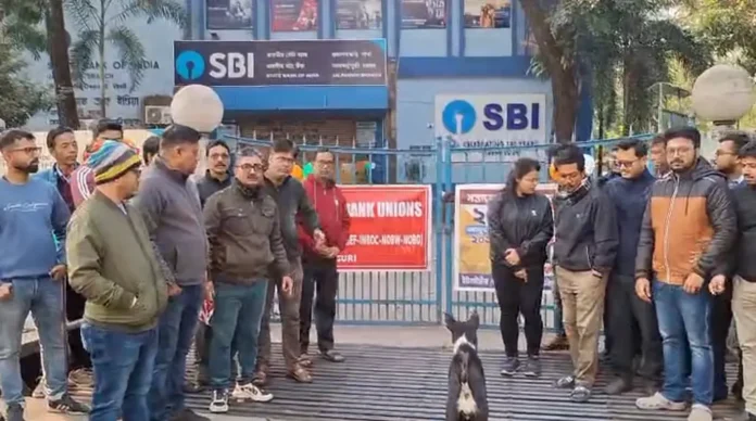 Bank employees stage a protest outside an SBI branch in Jalpaiguri on Tuesday, demanding the introduction of a five-day work week as part of a nationwide strike. Tuesday, 27 January 2026.