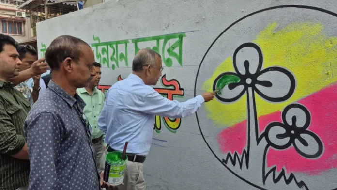TMC workers paint party slogans on city walls in Siliguri as part of the early Assembly election campaign drive on Tuesday. 24 February 2026.