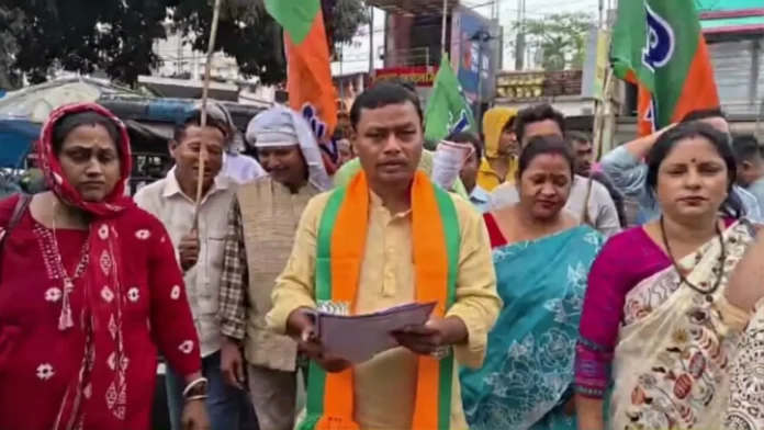 BJP candidate Anandamay Barman interacts with locals during a rain-soaked campaign visit at Naxalbari market. Saturday, 21 March 2026.