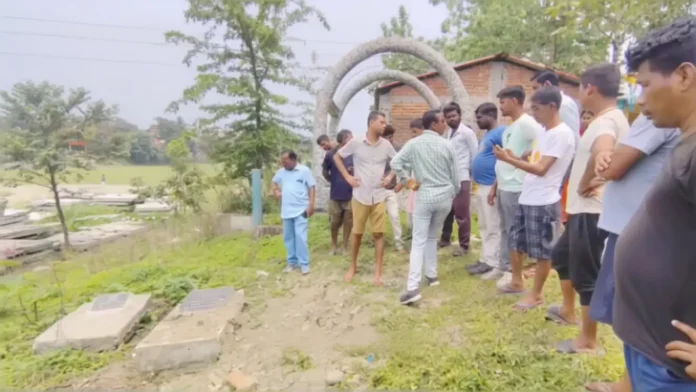 Police and locals gather at the burial ground in Siliguri’s Prakash Nagar after suspected tampering of an infant’s grave triggered tension in the area. Thursday, 16 April 2026.