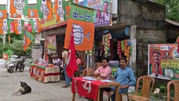 Party workers from TMC, BJP and CPM sit side by side at Ambari Business Colony, assisting voters during peaceful polling in Rajganj. Thursday, 23 April 2026.